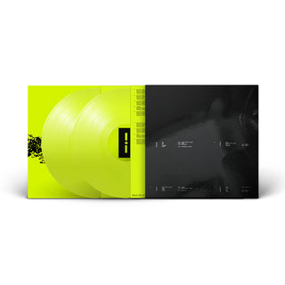 A vinyl record package shown open against a light gray background, featuring two translucent neon yellow-green records and a black inner sleeve with printed track information.